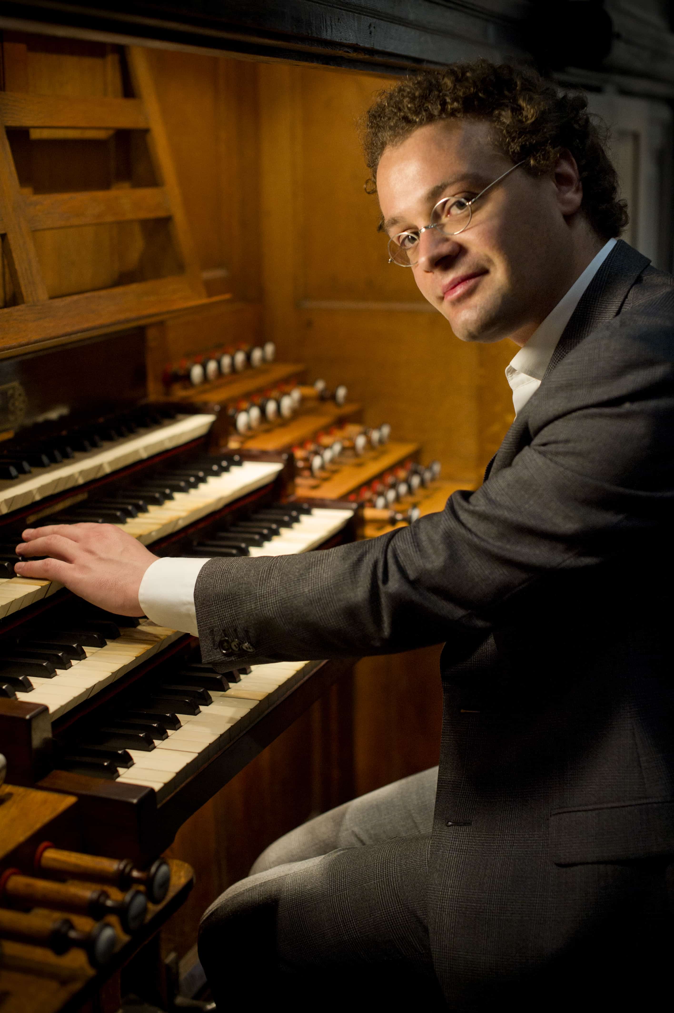 Man with glasses playing an organ